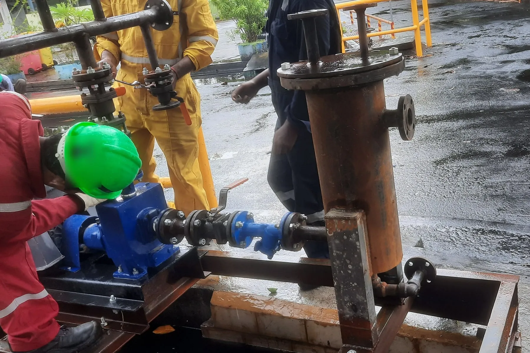 Field team connecting a pump and filter skid at a plant site