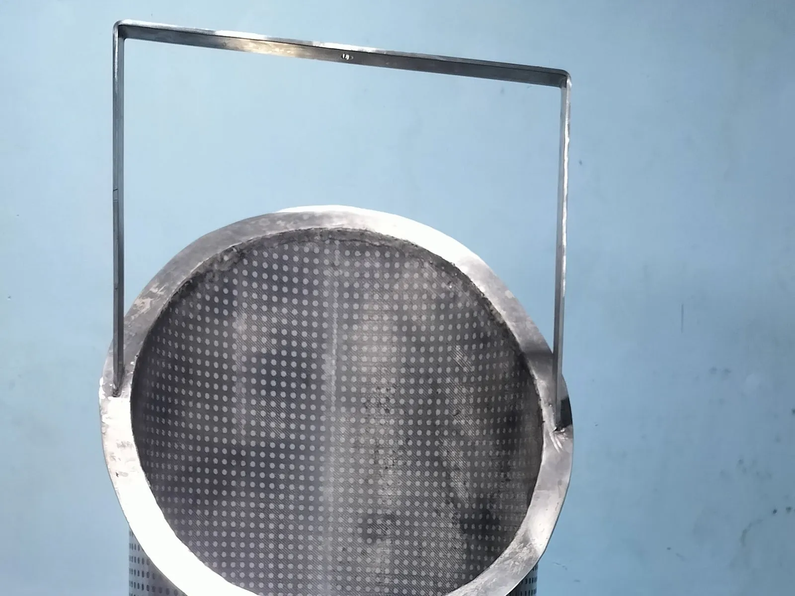 Perforated stainless-steel strainer basket with a lifting handle